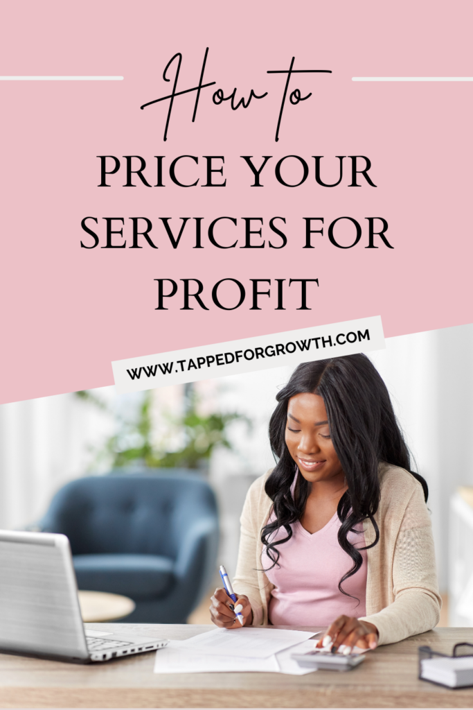 woman sitting at desk calculating business expenses